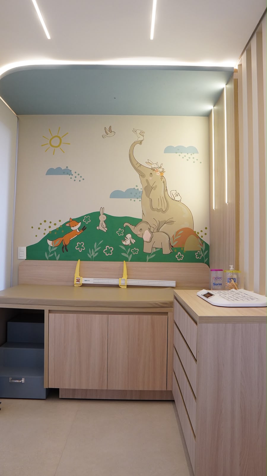Sala de atendimento do consultório, com mural de animais e régua de medição